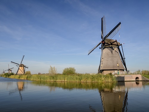 Three windmills and a river in Kinderdijk, the Netherlands